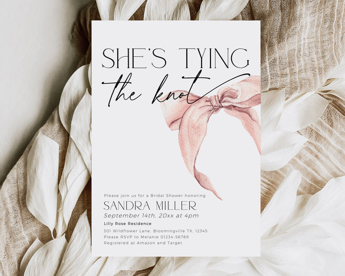 Elegant pink bridal shower invitation with “She Is Tying the Knot” text.